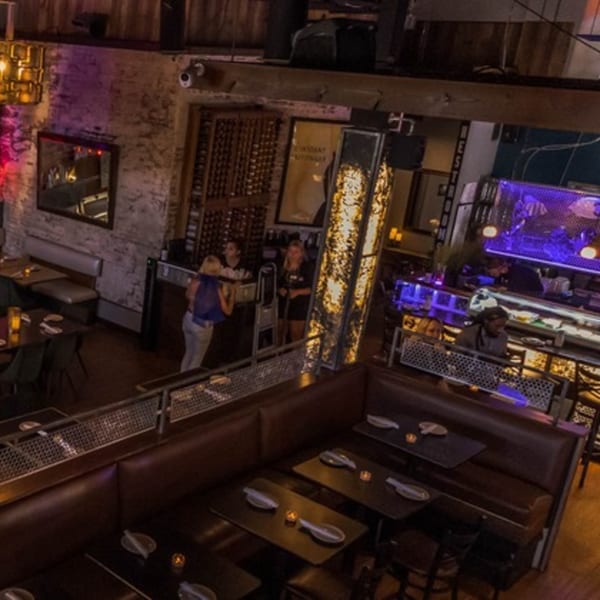 Overhead view of LYNQ restaurant with dining tables, booths, and a bar area with staff and patrons.